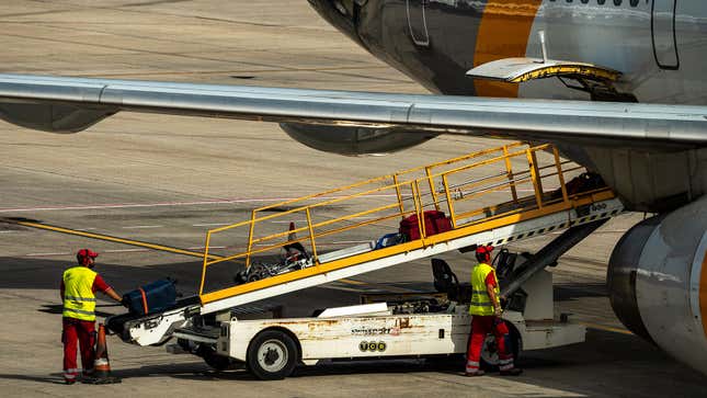 飛行機に荷物を積み込む作業員の写真。 